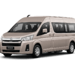 Toyota Hiace Premio Luxury coklat muda metallic tampak serong depan dan samping untuk layanan sewa Hiace Luxury Bandung dengan driver profesional